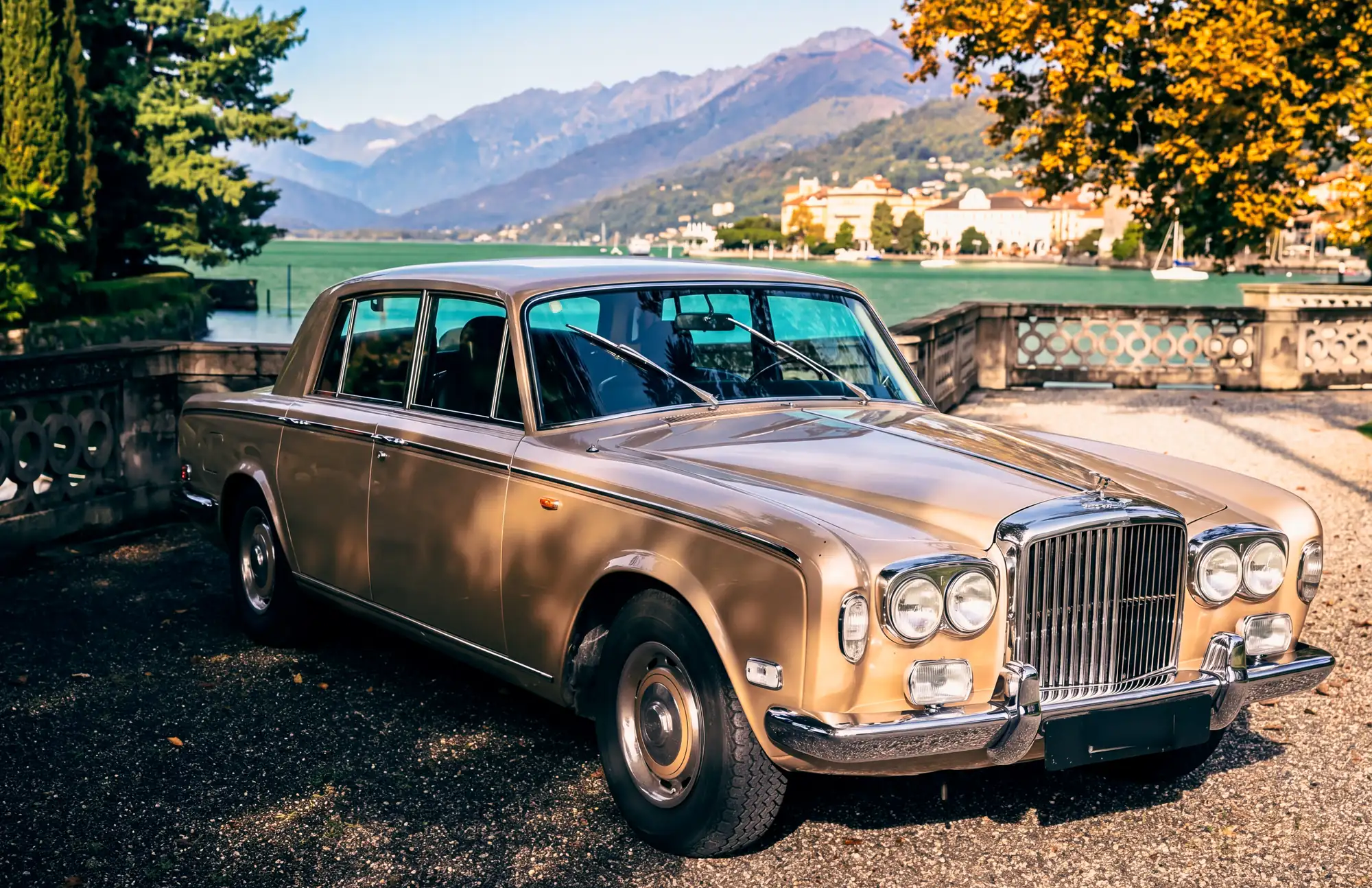 Una Bentley T color champagne ferma sul viale di una villa affacciata sul lago