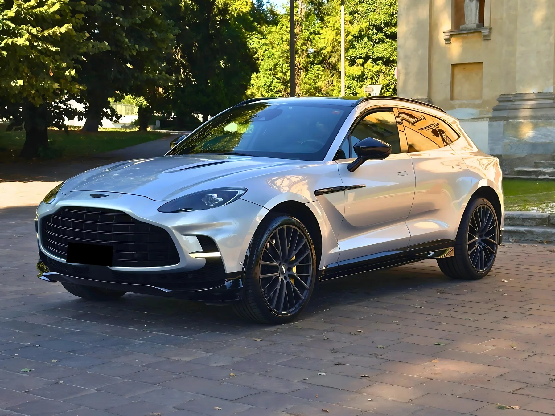 Aston Martin DBX 707 argento di tre quarti su un piazzale in pietra
