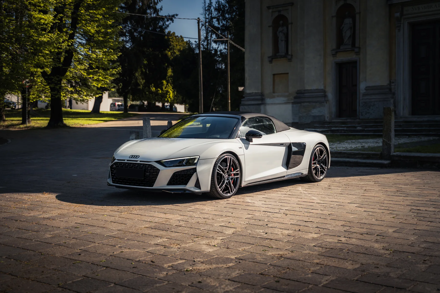 Spyder bianca a due posti di tre quarti su un piazzale in pietra