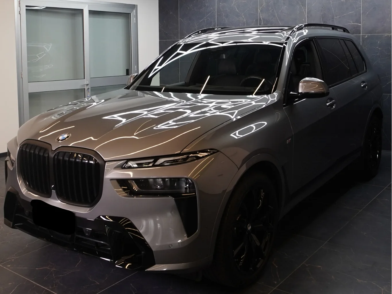 BMW X7 grigia di tre quarti in garage