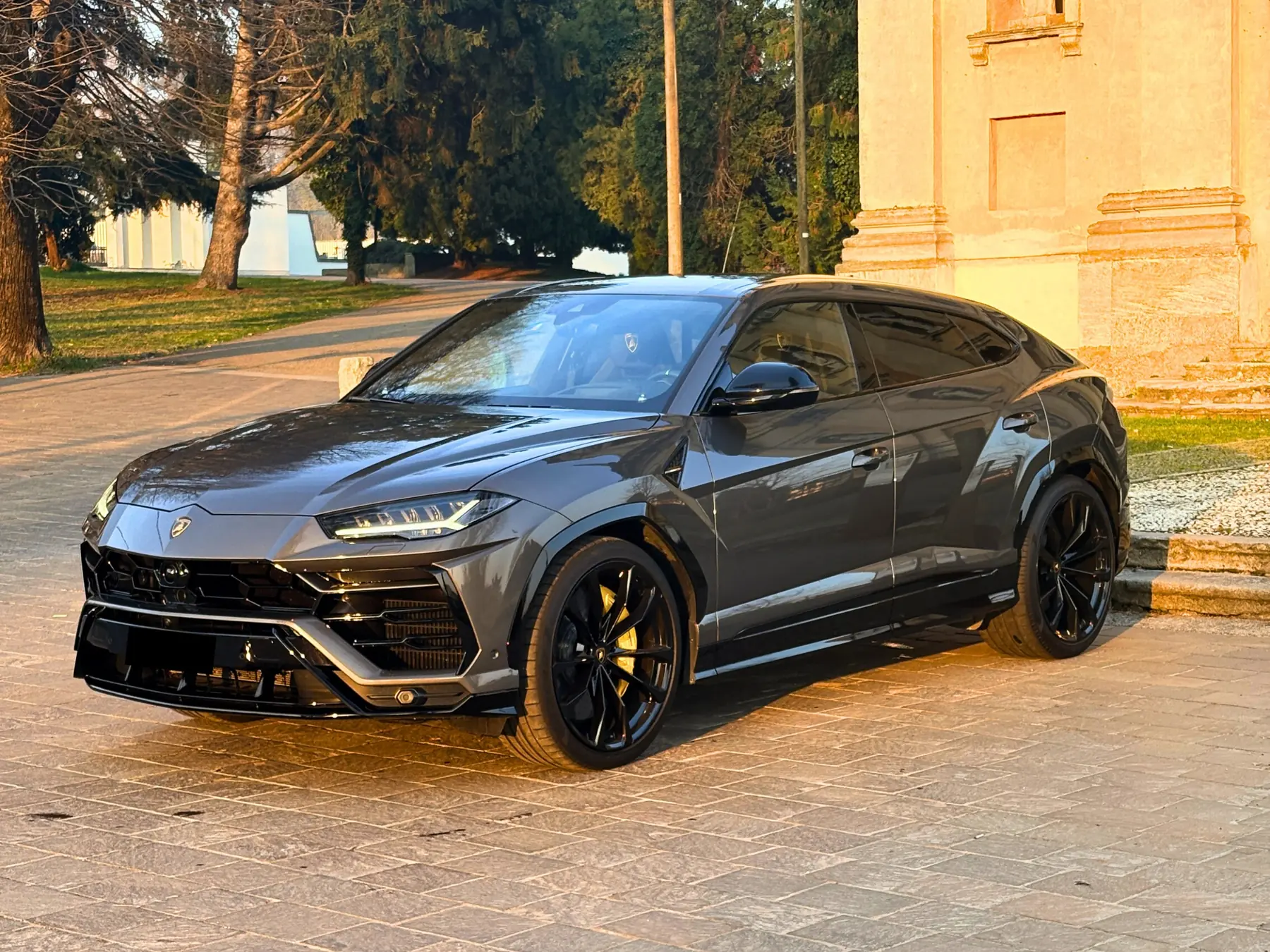 Lamborghini Urus grigia di tre quarti nella luce del tramonto