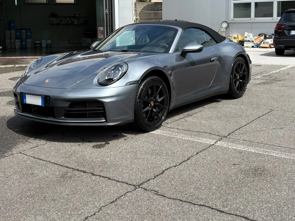 Porsche 911 Cabrio grigia di tre quarti, con la capote chiusa
