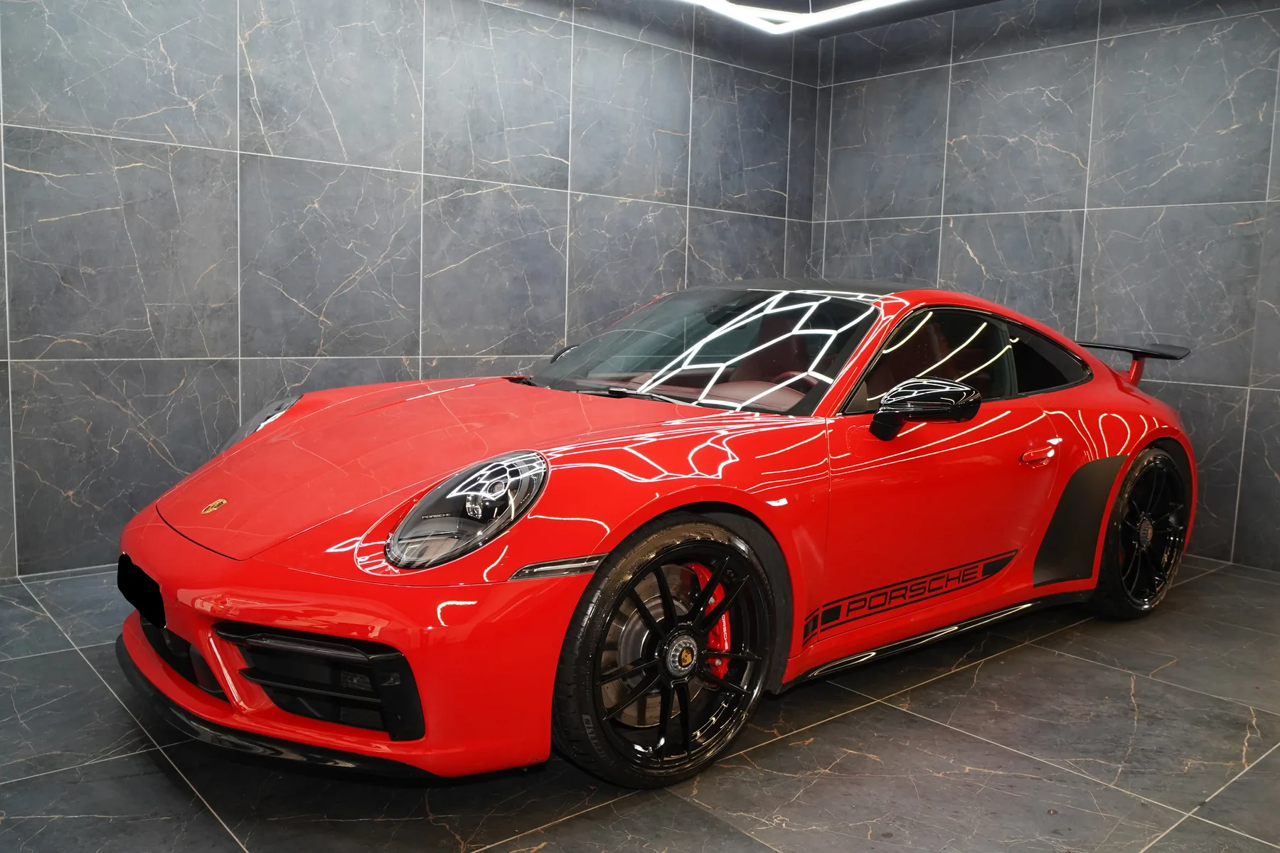 Porsche 911 Carrera GTS rossa di tre quarti in garage