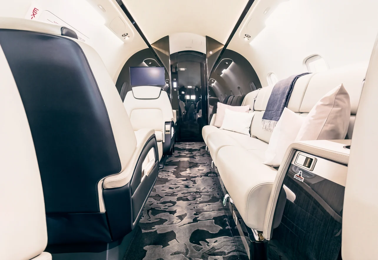 La cabina di un jet privato vista dal fondo, con il tavolo aperto