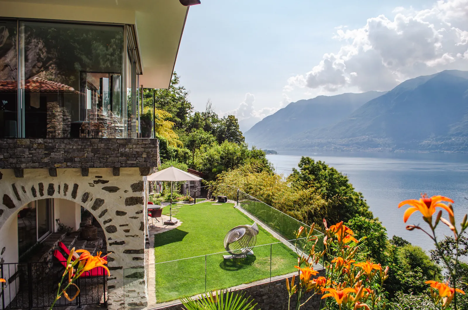 Il prato di una villa sul lago, con i gigli in fiore in primo piano