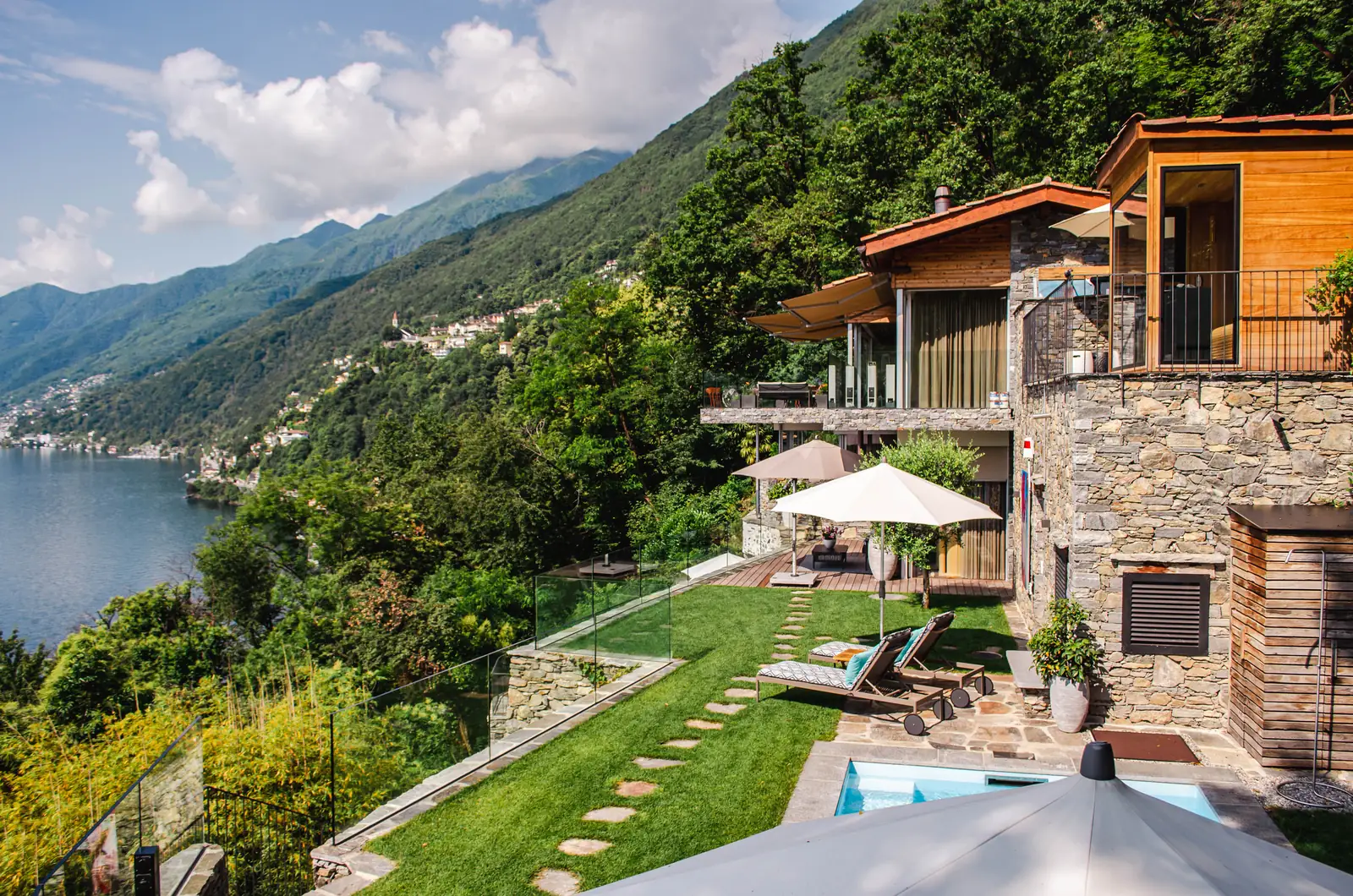 La piscina di una villa sul lago, con i lettini e la vista sull’acqua