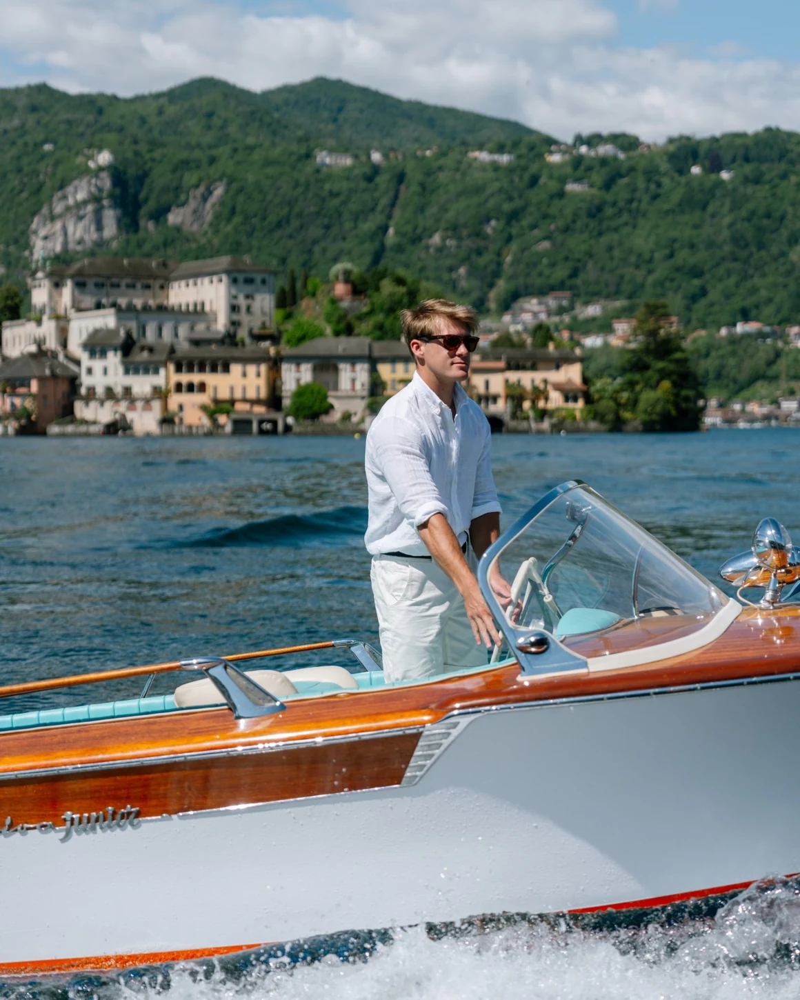 Al timone di un Riva d’epoca sul Lago d’Orta, con l’Isola di San Giulio sullo sfondo